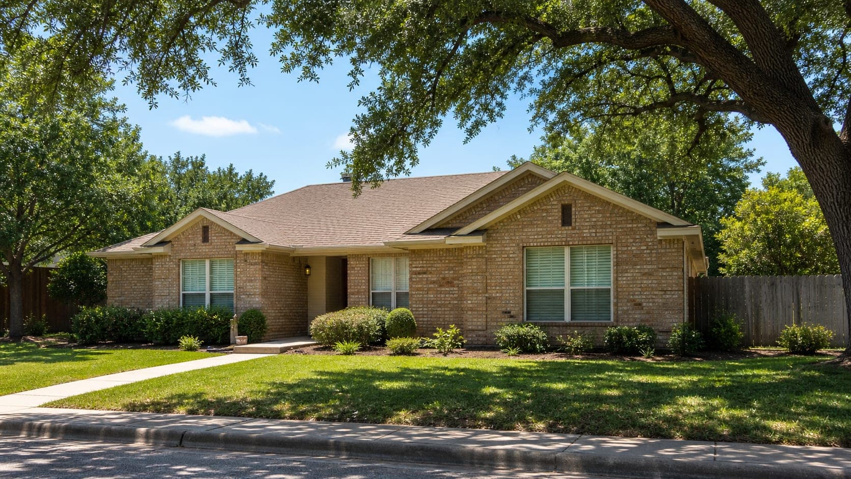 Texas home shaded by trees on a sunny afternoon to reduce heat gain.